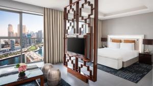 a hotel room with a bed and a large window at The First Collection Dubai Marina in Dubai