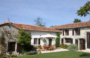 an exterior view of a white house with a patio at La Cotte Remote house for family getaway in Périgord in Nanteuil-de-Bourzac