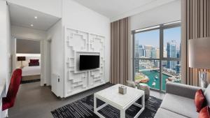 a hotel room with a living room with a large window at The First Collection Dubai Marina in Dubai