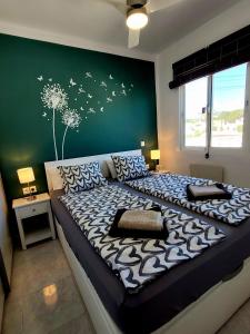 1 dormitorio con 1 cama grande con dientes de león en la pared en Casa Bella, en Mijas Costa