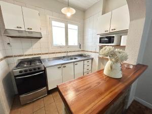 a kitchen with a table with a vase of flowers on it at Amplia casa en la 5ta sección ciudad con patio y parrilla in Mendoza
