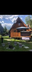 a large wooden building with a group of benches in the grass at Chata TATRY, in Vyšné Hágy +8 photos