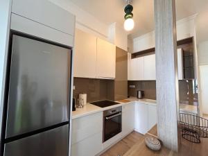 a kitchen with white cabinets and a stainless steel refrigerator at OpenSea #2 in Chalkida