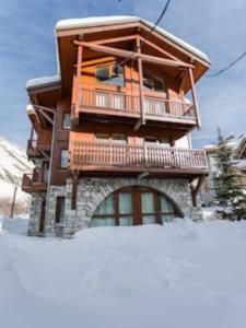a building with a balcony in the snow at Chalet Ancolie 2e Appartement cosy dans un chalet in Val dʼIsère