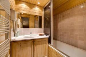 a bathroom with a sink and a bath tub at Chalet Ancolie 2e Appartement cosy dans un chalet in Val dʼIsère +16 photos
