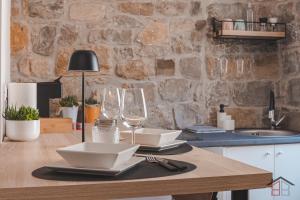 ムッジャにあるCALLE DE BERNARDIS 1 l BB APARTMENTS TRIESTEの木製テーブル(ワイングラスと皿付)