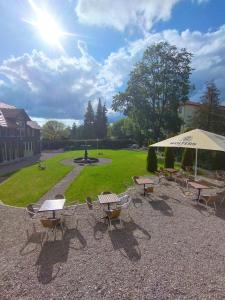 a group of picnic tables and an umbrella in a park at Unik Villa Brunnen Blick mit offenem Dachstuhl in Sankt Andreasberg
