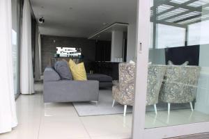 Una sala de estar con un sofá y algunas sillas. en Panorama Pool in the Cape, en Ciudad del Cabo