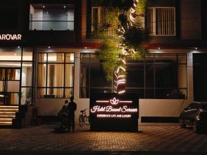 un hombre parado junto a una señal frente a un edificio en Hotel Basant Sarovar, en Mathura