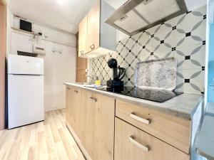 eine Küche mit Holzschränken und einem weißen Kühlschrank in der Unterkunft Le Guillaumin, convivial et zen in Limoges