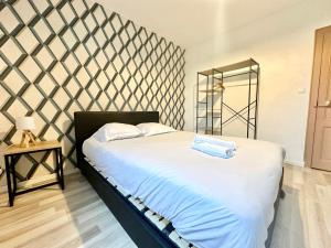 ein Schlafzimmer mit einem großen Bett mit einer Schachbrettwand in der Unterkunft Le Guillaumin, convivial et zen in Limoges + 9 Fotos