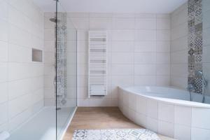 a white bathroom with a tub and a shower at Villa Arthur in Deauville +19 photos