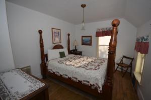 a bedroom with a bed and a chair in it at Somewhere In Time in Cedar