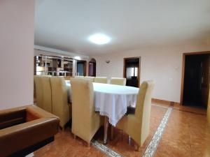 a dining room with a white table and chairs at Casa Graur in Soveja