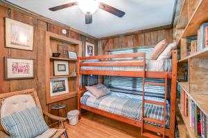 FaxonLakefront New Concord Paradise with Screened Porch!的有两张双层床和一把椅子的房间