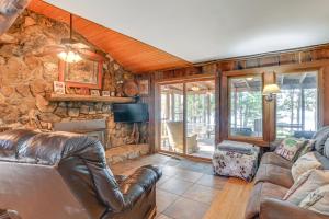 FaxonLakefront New Concord Paradise with Screened Porch!的客厅配有皮革家具和石墙