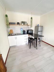 a kitchen with a table and a refrigerator at Cozy Cottage in Langebaan +9 photos