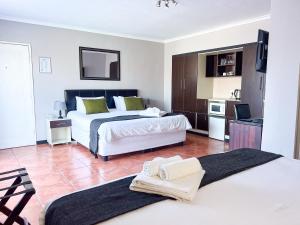 a hotel room with two beds and a kitchen at Ilanga Du Cap Hotel in Cape Town +46 photos