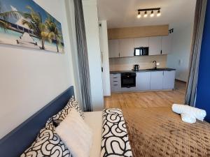 a living room with a couch and a kitchen at Apartament OneStreet in Katowice