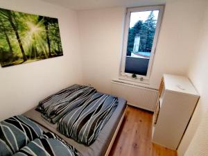 a small bedroom with a bed and a window at Ferienwohnung Thomas Müntzer in Mühlhausen
