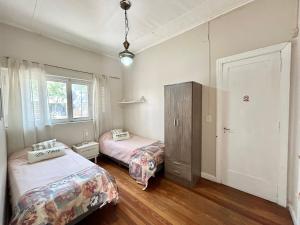 a bedroom with two beds and a cabinet in it at Amplia casa en la 5ta sección ciudad con patio y parrilla in Mendoza
