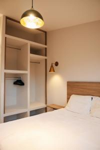 a bedroom with a white bed and a lamp at Casa Lomas in Oaxaca City