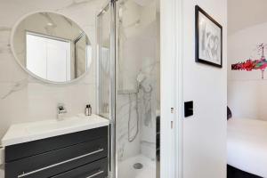 une salle de bain avec une douche, un lavabo et un miroir dans l'établissement Résidence Paris Charonne-Bastille, à Paris 37 autres photos