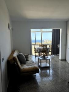 una sala de estar con un sofá y una mesa en Heart of Las Americas Charming Beach Apartment Tenerife, en Costa de Adeje