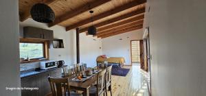 a kitchen and dining room with a table and chairs at Turismo y Cabañas Dragon de La Patagonia in Cochrane