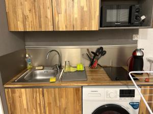 a kitchen with a sink and a washing machine at Studio Turkoise in Saint-François
