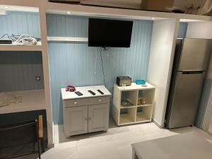 a kitchen with a tv on the wall and a refrigerator at Studio Turkoise in Saint-François