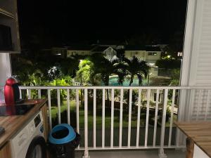 a balcony with a view of a yard at night at Studio Turkoise in Saint-François