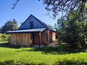 a barn with a gambrel roof on a grass field at TRAFO DOM - Podlesice 74 in Podlesice