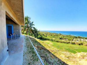 a house with a view of the ocean at Experience mesmerizing views at The Cliff House from your private plunge pool in Aguadilla