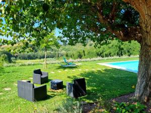 a group of chairs sitting in the grass under a tree at Villa Lorenzana in Lorenzana +8 photos