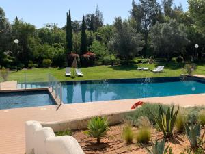- une piscine dans une cour avec des chaises et des arbres dans l'établissement Vilamoura Club Villa 1 With Pool by Homing, à Vilamoura