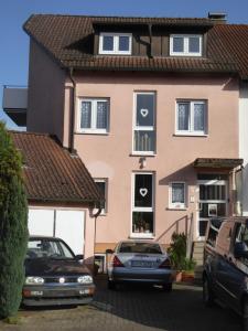 a house with two cars parked in front of it at Ferienwohnung in Rheinstetten