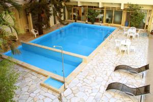 a swimming pool with a patio and a table and chairs at Soder Hotel in Santa Cruz do Sul