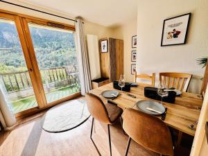 une salle à manger avec une table et des chaises et une fenêtre dans l'établissement Les 3 Vallées, Appartement Montagnard avec Spa et Piscine, à Orelle