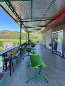 a patio with tables and chairs on a balcony at TuTu's Homestay Phong Nha in Phong Nha