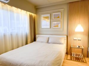 a bedroom with a white bed with a window at ห้องพักเมืองทองธานี Happiness sleep C4 in Ban Bang Phang +3 photos