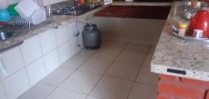 a kitchen with a trash can sitting on the floor at Chalé jane in Caldas Novas