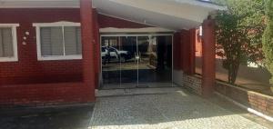 a front door of a house with a car in the driveway at Chalé jane in Caldas Novas