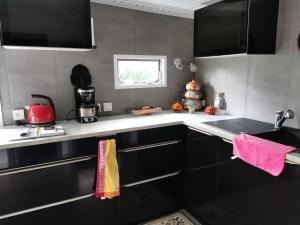 a kitchen with black and white cabinets and a sink at Chalet Paradise Cottage in Hastière-par-delà +85 photos