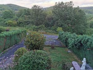 a garden with bushes and a river in the background at Chalet Paradise Cottage in Hastière-par-delà