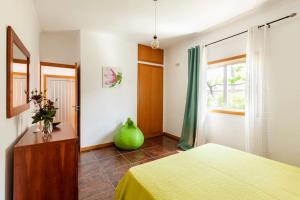 a bedroom with a yellow bed and a window at Casa do Fontanário in Penafiel
