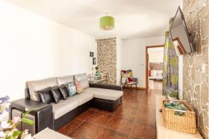a living room with a couch and a tv at Casa do Fontanário in Penafiel