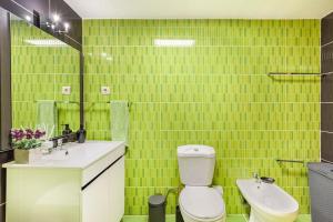 a green tiled bathroom with a toilet and a sink at Casa do Fontanário in Penafiel +19 photos