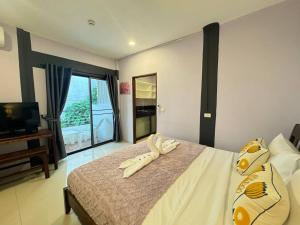a bedroom with a large bed with a television and a bedskirtspectspectspects at Pupa Rooms in Patong Beach