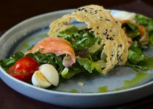 a plate of food with a salad on a table at Vyshegrad Castle Hotel in Vyshhorod